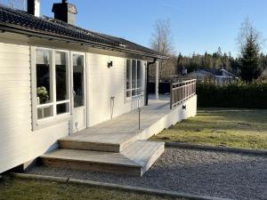eine Veranda eines Hauses mit einer Holzterrasse in der Unterkunft Nice cottage located by the lake Nommen in Björköby