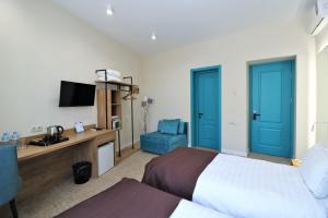 Habitación de hotel con cama y puerta azul en City Inn Tbilisi, en Tiflis
