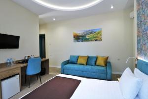 um quarto de hotel com uma cama e um sofá em City Inn Tbilisi em Tbilisi