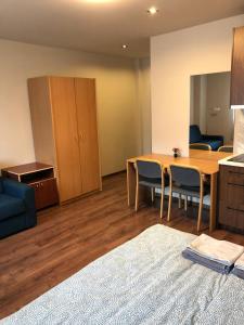a living room with a table and chairs and a kitchen at RVR Smart Apartments Riga with Self Check-In in Rīga