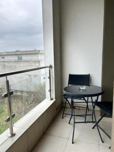 una mesa y una silla en un balcón con ventana en Airport Residence, en Otopeni