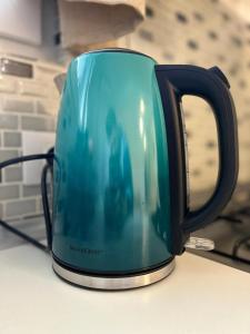 a green coffee pot sitting on top of a counter at Airport Residence in Otopeni