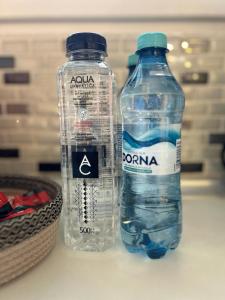 two bottles of water are sitting on a counter at Airport Residence in Otopeni