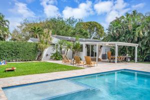 a swimming pool in a yard with a table and chairs at Samadhi - NEW 15 min drive to Ultra, by Newman Hospitality in Miami Shores