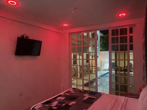 a room with a bed and a tv on a wall at HCEAS villa is 5 min fr. airport & to the beaches in Bon Accord