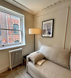 a living room with a couch and a window at Luxury Shoreditch One Bedroom Apartment in London