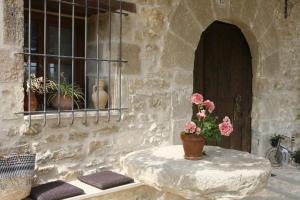un edificio de piedra con una mesa con flores. en Hort de L'Aubert, en Cretas