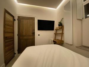 a bedroom with a bed and a television on the wall at Roxy's Fishmarket in Leuven +7 photos