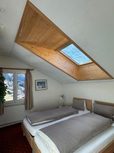 a bedroom with a large bed with a skylight at Hotel Residence in Grindelwald