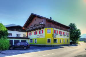 um edifício com um carro estacionado em frente em Hotel zum Schwanen - Appartement 6 em Pflach