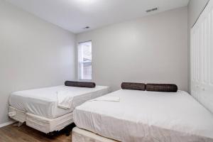 Duas camas num quarto branco com uma janela em Suite 2 on Southport 4 Queen Beds em Chicago