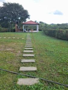 a stepping stone path in a field with a gazebo at cabaña la soñada in Palomino