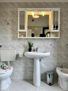 ein Badezimmer mit einem Waschbecken, einem WC und einem Spiegel in der Unterkunft Bnbook Casa Giolito in Castelletto sopra Ticino