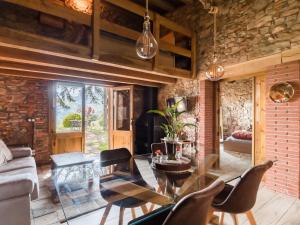 sala de estar con mesa de cristal y sillas en Masia de Can Ferrer, en Arbúcies