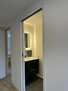 a bathroom with a mirror and a sink in it at Résidence le Prorel in Saint-Chaffrey