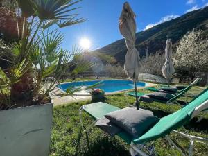 a pool with chairs and umbrellas in front of a house at Cal Pastor in Oden