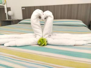 Una cama con toallas con forma de cisne en B&B Incanto Salento, en Ugento