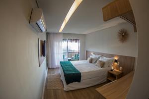 a hotel room with a bed and a window at Pousada Divino Morro in Fernando de Noronha