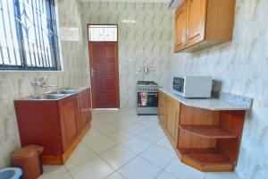 - une cuisine avec un évier et un comptoir dans l'établissement GOWON BnB, à Bunju