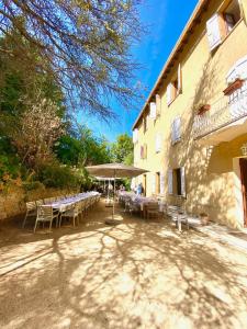 a table with chairs and an umbrella next to a building at Beau Séjour in Bocognano