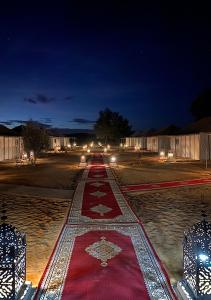 a red rug on a street at night at Explore merzouga luxury camp in Merzouga