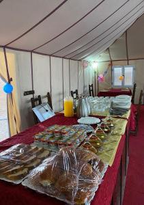a table in a tent with plates of food on it at Explore merzouga luxury camp in Merzouga
