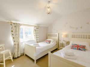 a bedroom with two beds and a window at 3 Bed in Thornham KT104 in Thornham