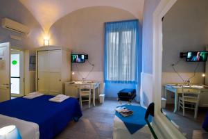 Cette chambre d'hôtel comprend deux lits, une table et des chaises. dans l'établissement Il Giardino di Tonia - Oplontis Guest House - Bed & Garden -, à Torre Annunziata