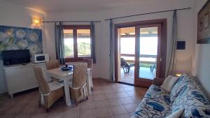 a living room with a couch and a table at VILLETTA TRAMONTO - INFINITYHOLIDAYS in Costa Paradiso