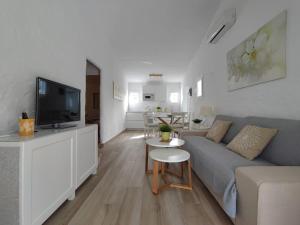 a living room with a couch and a tv at Relax bungalow with parking in Playa del Ingles