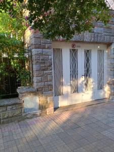 a white front door of a stone building at Departamento Fratellino a pasos del Hospital Rossi in La Plata