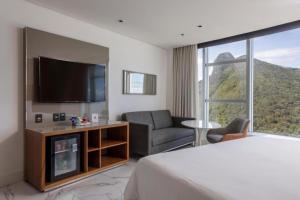 ein Hotelzimmer mit einem Bett und einem TV in der Unterkunft Hotel Nacional Rio de Janeiro in Rio de Janeiro
