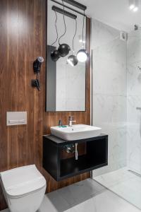 W łazience znajduje się umywalka, lustro i toaleta. w obiekcie Pensjonat eSENtia w mieście Zgorzelec