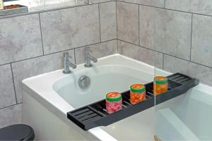 a bathroom sink with a tray with food on it at A Cosy, Elegant 3 Bed Suite in Killingbeck