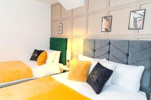 ein Hotelzimmer mit 2 Betten und einem Sofa in der Unterkunft A Cosy, Elegant 3 Bed Suite in Killingbeck