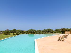ein Schwimmbecken mit zwei Liegestühlen daneben in der Unterkunft Agua Green Resort in Reitani