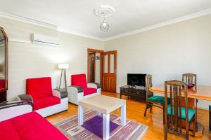 een woonkamer met rode stoelen en een tafel bij Cozy Flat with Balcony 10 min to Hadrian Gates in Antalya