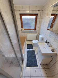 La salle de bains est pourvue d'un lavabo, d'une baignoire et de toilettes. dans l'établissement Fewo - klein aber fein, 1-3 Personen, Souterrain, à Rödental