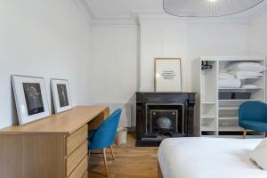 a bedroom with a bed and a desk and a fireplace at 10' de Lyon- Appartement Tassin Centre - 2 Parking in Tassin-la-Demi-Lune