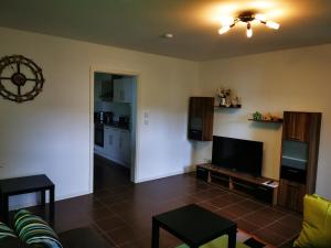 a living room with a couch and a flat screen tv at Ferienwohnung am Waldpfad in Kaiserslautern