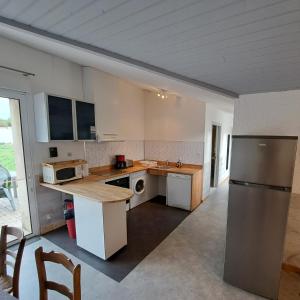 a kitchen with a refrigerator and a counter top at Les logis de Simon in La Flotte