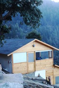 a large wooden building with a large window at THE GRAND RESORT DHANOLTI in Dhanaulti