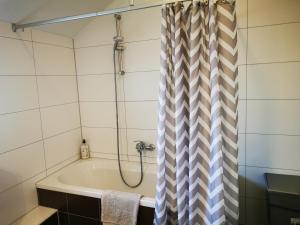 y baño con bañera y cortina de ducha. en Ferienwohnung am Waldpfad en Kaiserslautern