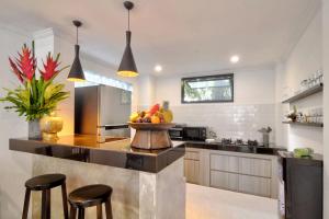una cocina con una barra con un bol de fruta. en Selasih Beach House, en Seminyak
