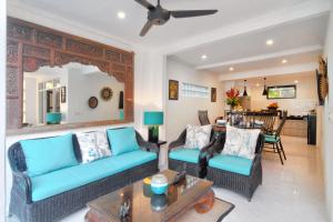 a living room with a blue couch and chairs at Selasih Beach House in Seminyak