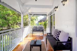a screened in porch with a couch and a table at Selasih Beach House in Seminyak