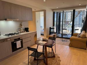 a kitchen and living room with a table and chairs at The Forest in the heart of CBD in Adelaide