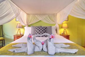 Una cama con dos pares de calcetines. en Selasih Beach House, en Seminyak 14 fotos más