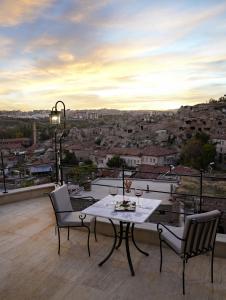 una mesa y sillas en un balcón con vistas en My Cave Suites en Nevşehir