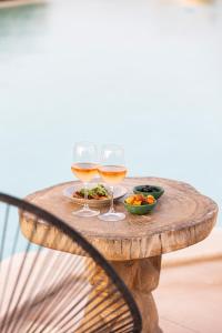 two glasses of wine and a plate of food on a table at Agua Green Resort in San Lorenzo